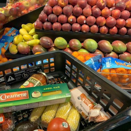 Fresh produce and grocery cart Cart in produce section of grocery store with pasta, sauce, produce and lentils in it