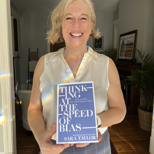Sara Taylor, holding a copy of her book, Thinking at the Speed of Bias
