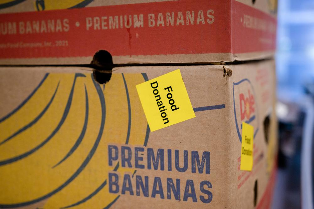 A box with a picture of bananas on it with a "food donation" sticker