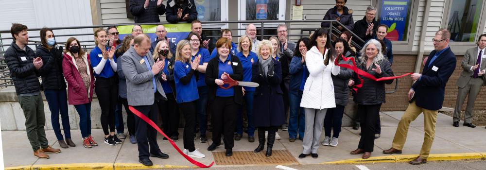 A group of people clap after ribbon cutting ceremony 