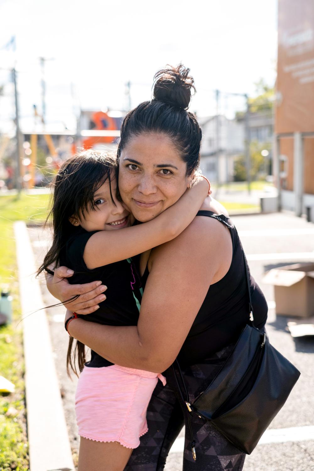 A woman and child outside, embracing and smiling