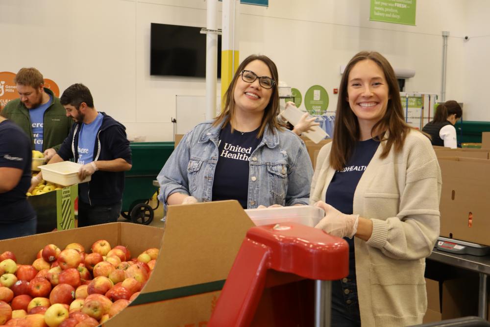 Two volunteers packing food