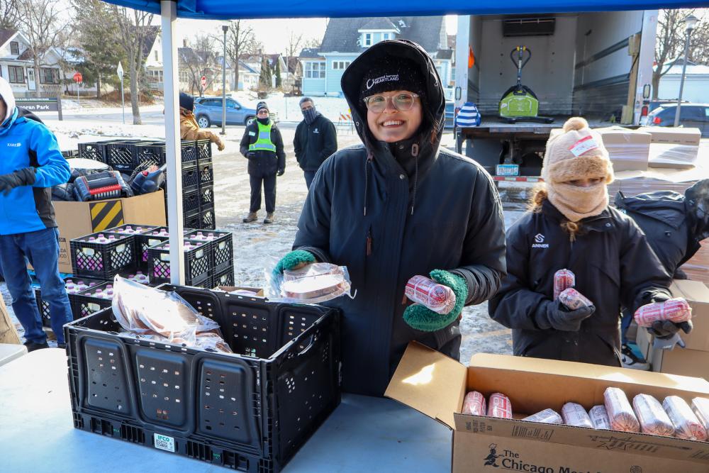 A Second Harvest Heartland volunteer hands out protein in the cold