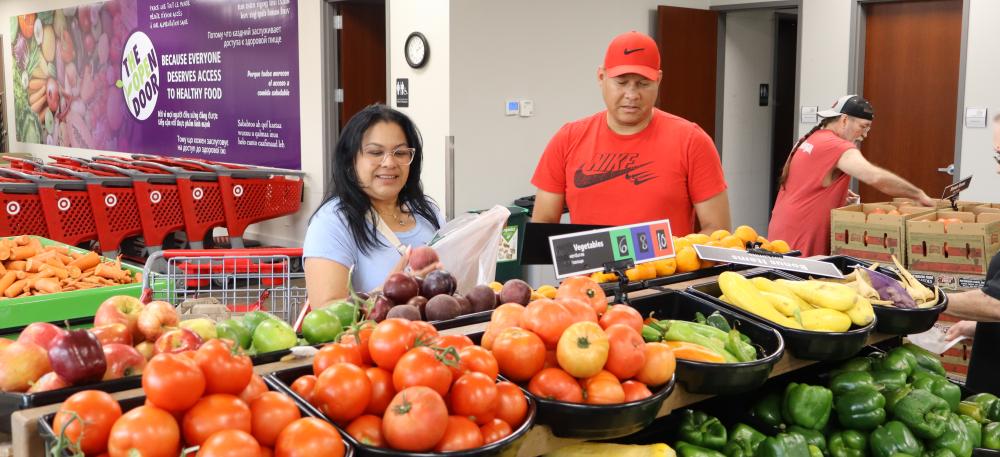 Two people pick out produce at a food shelf