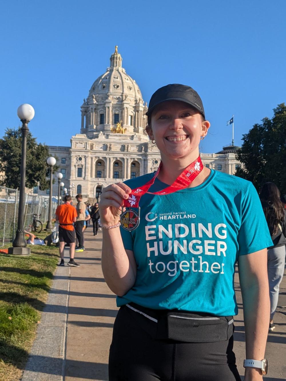 Person with their finishers medal from the Twin Cities Marathon