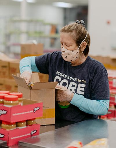 A volunteer packs a FOODRx box in the Volunteer Center