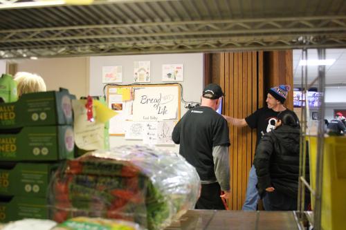 Volunteers helping a shopper at Bread of Life Food Pantry