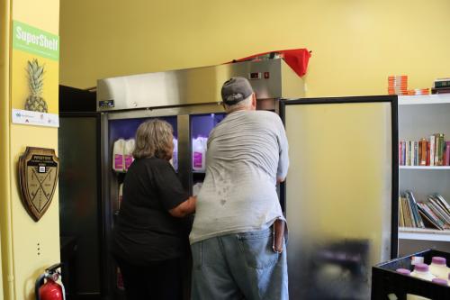 Volunteers stock the milk fridge