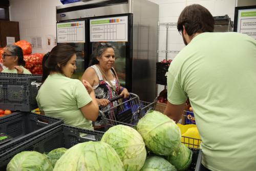 A group of people standing around fresh produce