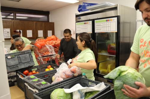 A woman checks out shoppers at a food shelf