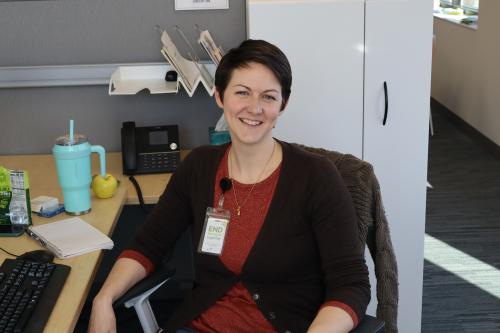 A person posing while sitting at a desk