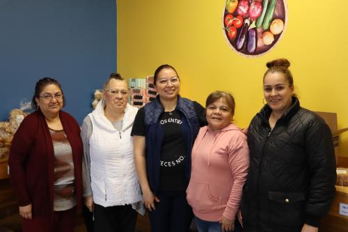 A group of five women posing in a food shelf