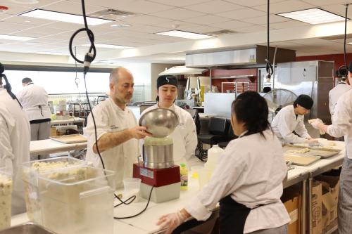 A chef pours from a mixing bowl