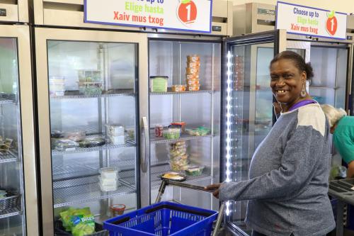 A woman shops in front of a cooler