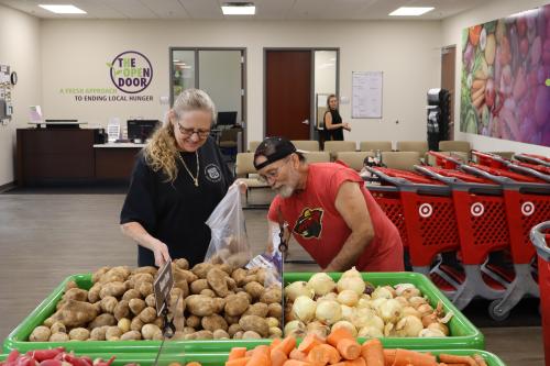 Two shoppers select produce