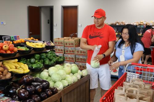 A husband and wife shop for vegetables