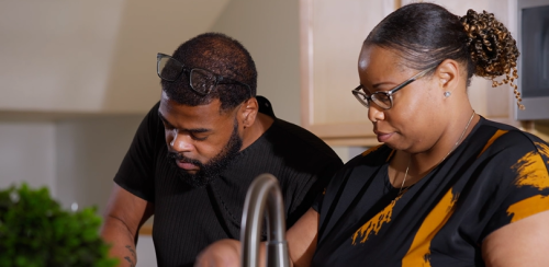 A man and a woman chopping up vegetables