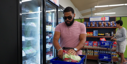 A man in sunglasses shopping at a food shelf